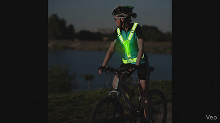 GlowStride LED Reflective Running Vest — Night cyclist wearing safety vest over jersey